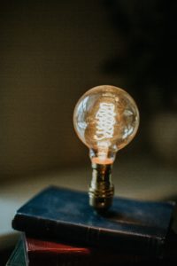 Decorative photo: A lightbulb on a stack of old books